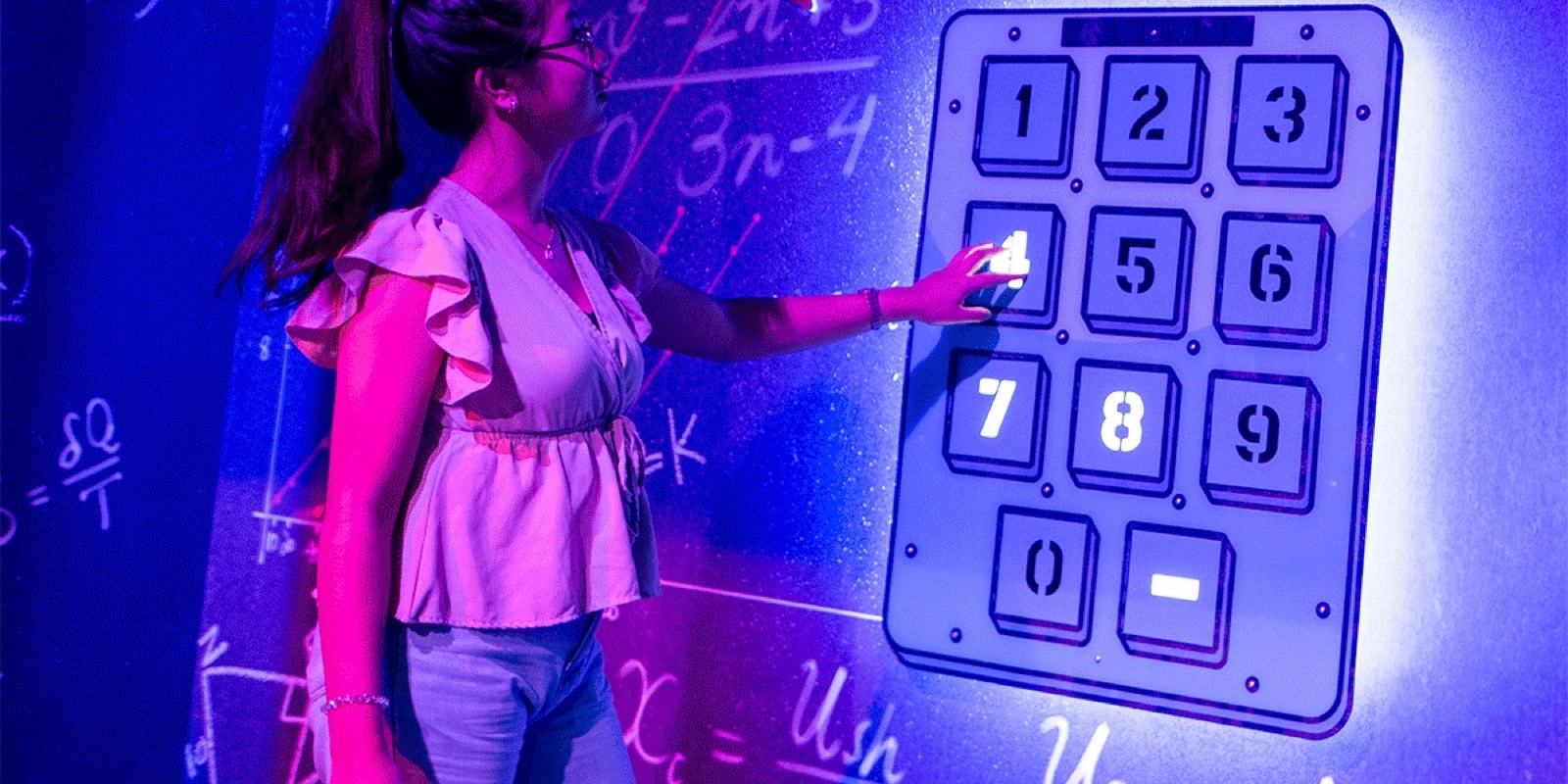 A player pressing numbers on the giant keypad in the Genius room